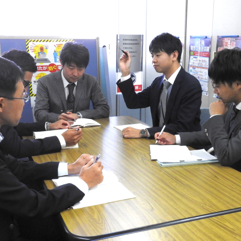 課内ミーティングで説明する若手職員